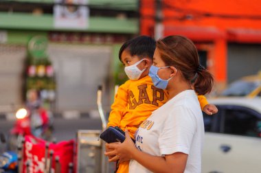 Koh Samui, Tayland - 30 Mart 2020: Küçük çocuk ve annesi yiyecek bulmak için yerel bir markete geldiler. Her ikisi de Coronavirus COVID-19 'un yayılmasını önlemek için maske takıyor..