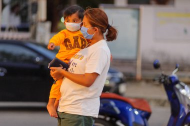 Koh Samui, Tayland - 30 Mart 2020: sokak satıcıları çalışmaya devam ediyor, küçük çocuk ailesiyle yiyecek almaya geliyor. Önlemler alındı: el dezenfektanı, satıcıların maskeleri ve onların küçük müşterileri ve anneleri..