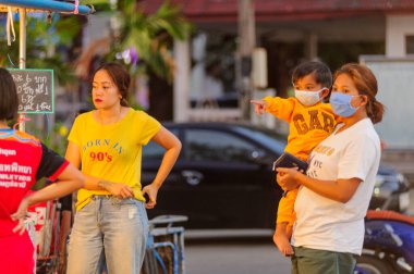Koh Samui, Tayland - 30 Mart 2020: sokak satıcıları çalışmaya devam ediyor, küçük çocuk ailesiyle yiyecek almaya geliyor. Önlemler alındı: el dezenfektanı, satıcıların maskeleri ve onların küçük müşterileri ve anneleri..