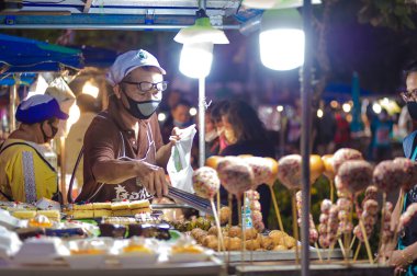Koh Samui, Tayland - 30 Mart 2020: sokak satıcıları çalışmaya devam ediyor, küçük çocuk ailesiyle yiyecek almaya geliyor. Önlemler alındı: el dezenfektanı, satıcıların maskeleri ve onların küçük müşterileri ve anneleri..