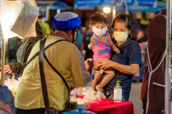 Koh Samui, Tayland - 30 Mart 2020: sokak satıcıları çalışmaya devam ediyor, küçük çocuk ailesiyle yiyecek almaya geliyor. Önlemler alındı: el dezenfektanı, satıcıların maskeleri ve onların küçük müşterileri ve anneleri..