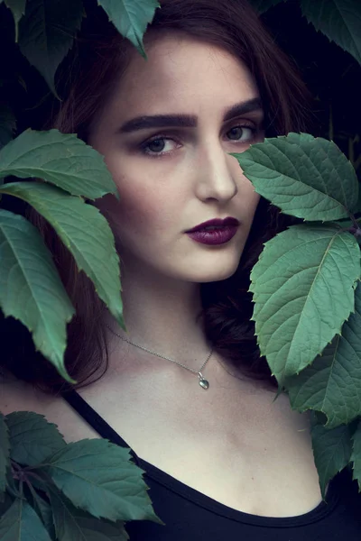 Ragazza in un cappello nero sorride leggermente — Foto Stock