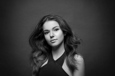 Güzel ve genç kız kameraya, esmer. Mor üst. Hafif makyaj, kahverengi gözlü, kahverengi saçlı. Siyah beyaz portre fotoğraflar. Saç bir rüzgarla geliştirmek. Temiz Cilt.