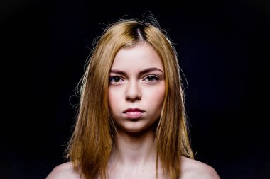 Kahverengi gözlü üzgün kız. Sarışın kısa saçlı. Doğruca kameraya bakıyor. Hafif bir makyaj. Pembe bir arka plan üzerinde siyah elbiseli kız. Genç ve güzel kadın temiz cilt ve mükemmel özellikleri ile.