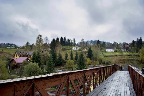 Vista desde el puente de las montañas. Pendientes de color verde oscuro y colinas de los Cárpatos. Bonita vista de las montañas. Temprano. Montañas cubiertas de nieve. Mañana brumosa. Ferrocarril . —  Fotos de Stock