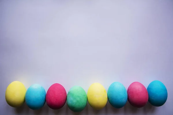 Tema Pascua. Huevos con tulipanes sobre tabla de madera, concepto de fiesta de Pascua. Copyspace para texto. En un plato, fondo blanco . —  Fotos de Stock