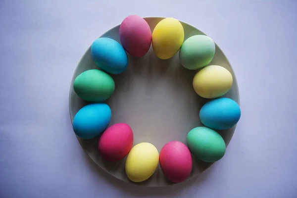 Tema Pascua. Huevos con tulipanes sobre tabla de madera, concepto de fiesta de Pascua. Copia espacio para texto. En un plato, fondo blanco . —  Fotos de Stock