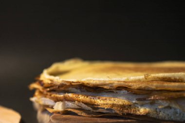 Tereyağı ve rustik arka plan üzerinde kahverengi tabakta bal ile ev yapımı krep yığını. Rus tatil krep hafta. Krep yerken üzerine odaklanır. Yatay görünüm.