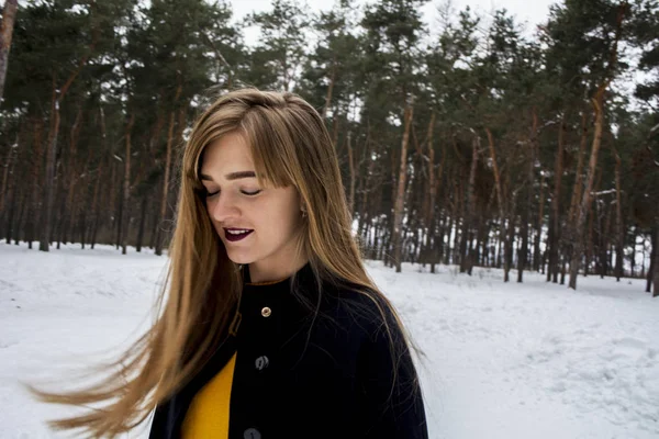 Piękna dziewczyna w śnieżnym lesie. Blondynka z długimi włosami. Uśmiechający się — Zdjęcie stockowe