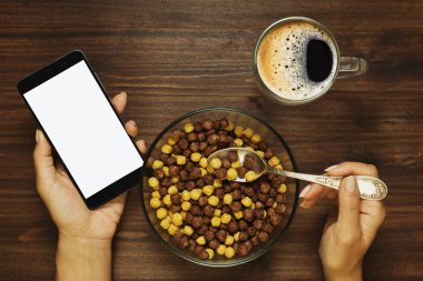 Elinde cep telefonu ile Kahvaltı
