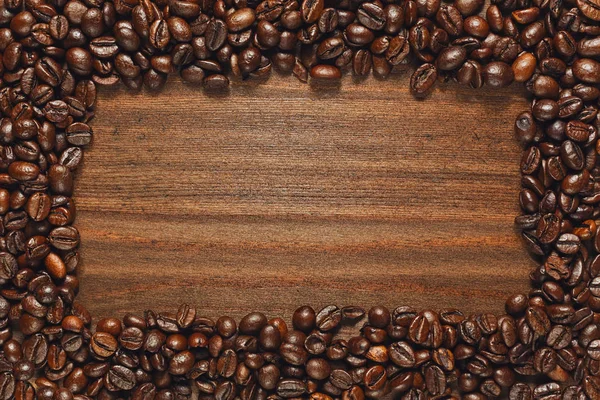 Coffee beans frame on wooden table — Stock Photo, Image