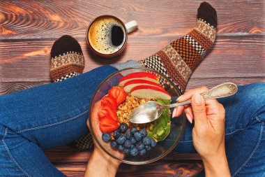 Kişi kahvaltı ahşap zemin üzerinde cross-legged olan