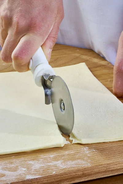 Hacer galletas Croissant con mermelada. Serie. Corte de masa con cortador — Foto de Stock