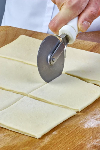 Hacer galletas Croissant con mermelada. Serie. Corte de masa con cortador — Foto de Stock