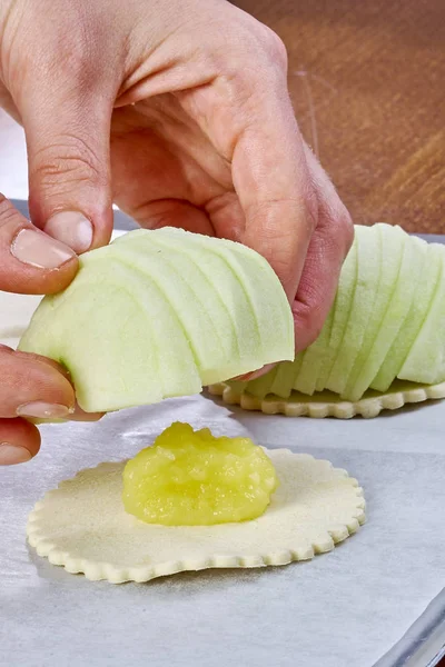 Повар кладет яблоко на тесто для сытного пирога — стоковое фото