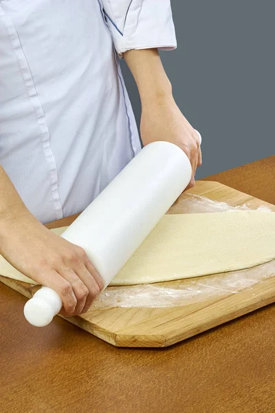 Extender la masa Primeros planos de cocinero panadero en uniforme delantal azul cocinar pizza en la cocina colección completa de recetas — Foto de Stock