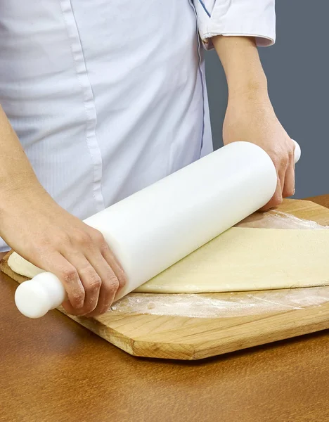 Rolar a massa Mão de close-up de padeiro chef em uniforme avental azul cozinhar pizza na cozinha coleção completa de receitas — Fotografia de Stock