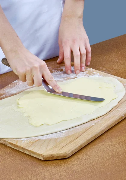 Chef esfrega manteiga na massa para a preparação de cozimento — Fotografia de Stock