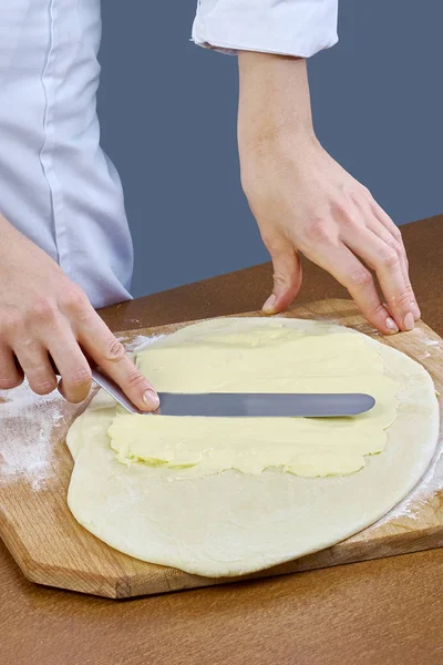 Chef schmiert Butter auf den Teig für die Vorbereitung des Backens — Stockfoto