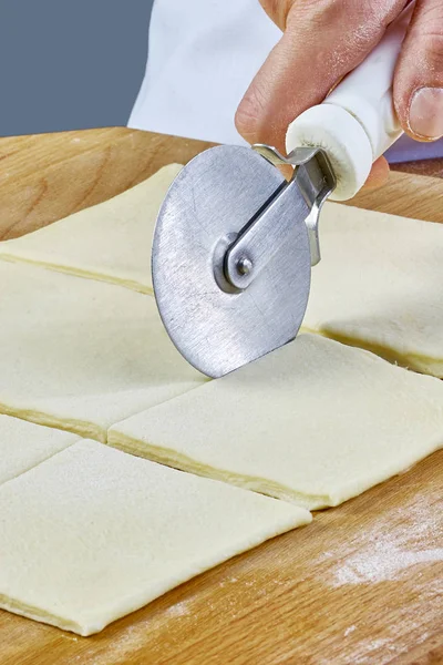 Hacer galletas Croissant con mermelada. Serie. Corte de masa con cortador —  Fotos de Stock