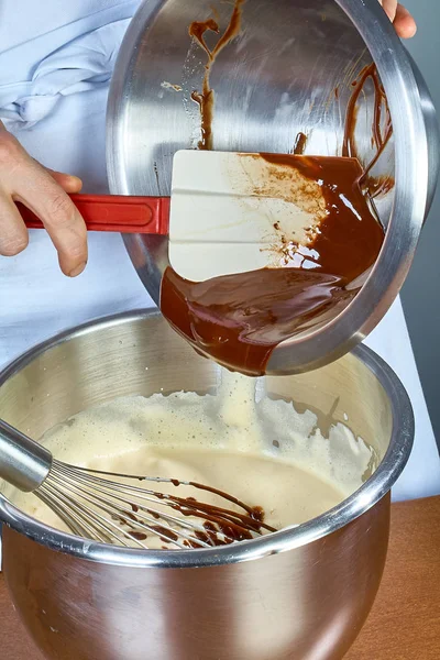 Cook prepares chocolate cream for cake