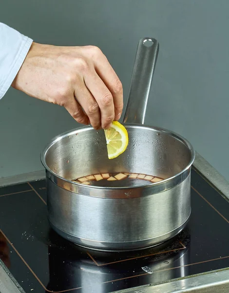 El cocinero sorbe los ingredientes en una sartén para cocinar vino caliente lleno de recetas culinarias — Foto de Stock