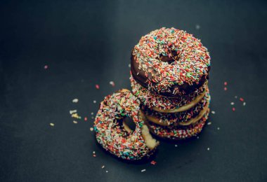 Siyah arka plan üzerinde renkli çörekler. Üstten Görünüm