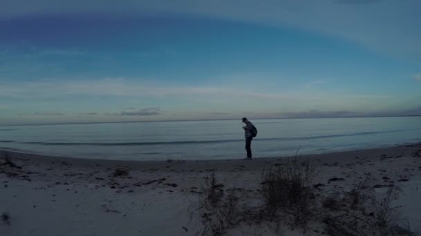 Moře, večerní slunce, krásný pohled shora. Cestovatel na pláži, natočeno DRONY. — Stock video