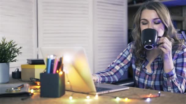 Pan tiro de mulher jovem trabalhando em um laptop no escritório casual . — Vídeo de Stock