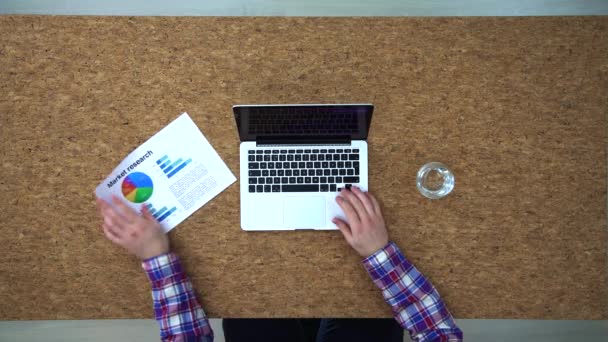 Pohled shora člověka psát na notebooku, kolegové dávat grafy — Stock video