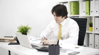Bir işadamı bir sarı yan görünüm kravat laptop yazma ve yazma