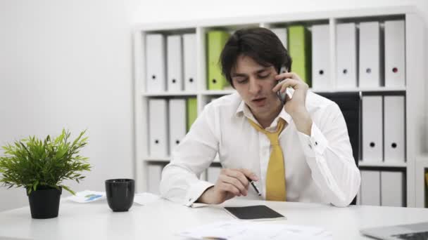 電話で話している男性の同僚を与える論文 — ストック動画