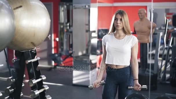 Sarışın kadın dumbbell egzersiz jimnastik salonu yapmak — Stok video