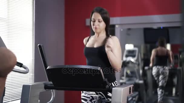 年轻女子在健身房跑步机上 — 图库视频影像