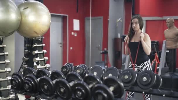 Woman doing situps with a rubber band in a gym — Stock Video