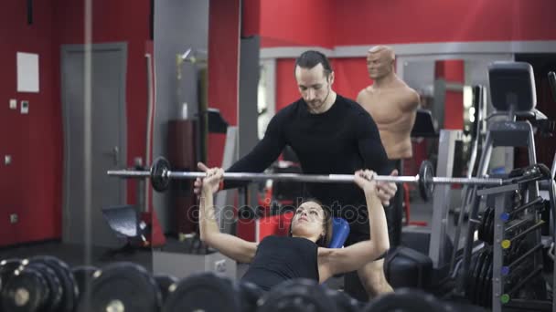 Coach, βοηθώντας την γυναίκα για την άρση της barbell — Αρχείο Βίντεο