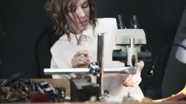 Kadın kuyumcu bir yüzük mikroskop altında incelenmesi