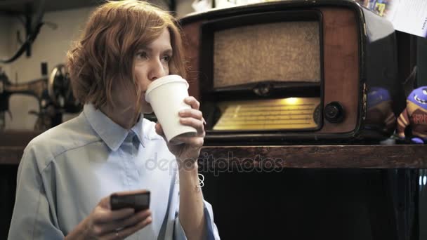 Kvinna som dricker kaffe och textilen i en pantbanken — Stockvideo