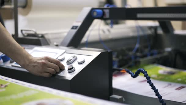 Mano del trabajador usando el engranaje en la máquina de la planta de impresión — Vídeos de Stock
