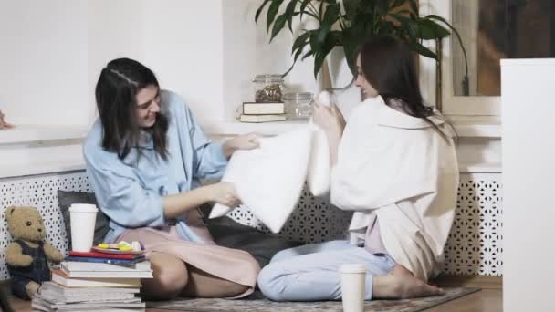 Две девушки дерутся на подушках — стоковое видео