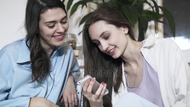 Twee vrouwen met mobiele telefoon praten thuis — Stockvideo