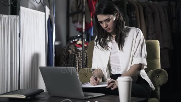 Mujer mirando la pantalla del ordenador portátil y la escritura — Vídeo de stock
