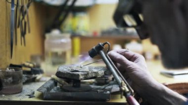 İşçi blowtorching küçük bir metal detay