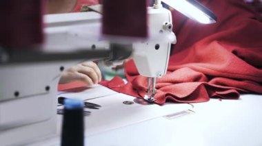 İş parçacığı kesme ve iki adet kırmızı kumaş dikiş kadın