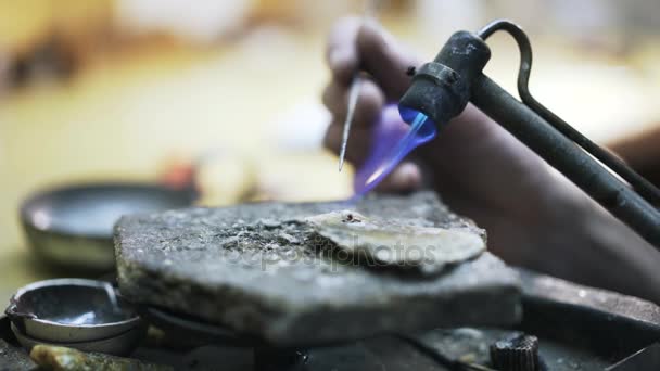 Worker with needle blowtorching a small metal detail — Stock Video