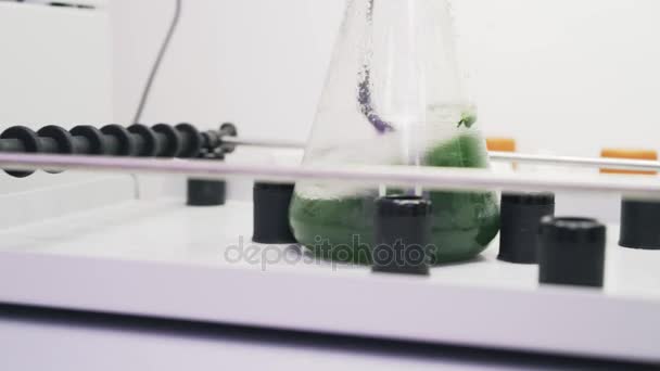 Gros plan d'un liquide vert agité dans une machine de laboratoire — Video