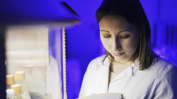 O femeie de știință se uită la centrifuga de lucru — Videoclip de stoc