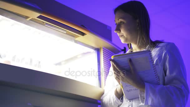 Retrato de mujer científica mirando el trabajo de la centrifugadora — Vídeo de stock