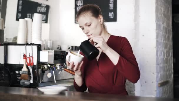 Mujer barista añadir leche a la taza de café — Vídeo de stock