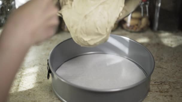 Vrouw gieten deeg aan een formulier — Stockvideo